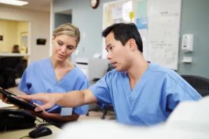 Two specialist doctors reviewing a patient appointment request from overbookMD.com